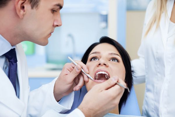 دندانپزشکی که با بیمار کار می کند