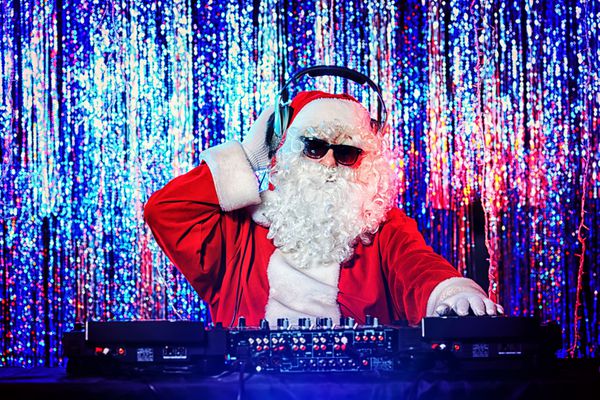 دی جی بابا نوئل در حال مخلوط کردن برخی از تشویق کریسمس چراغ های دیسکو در پس زمینه
