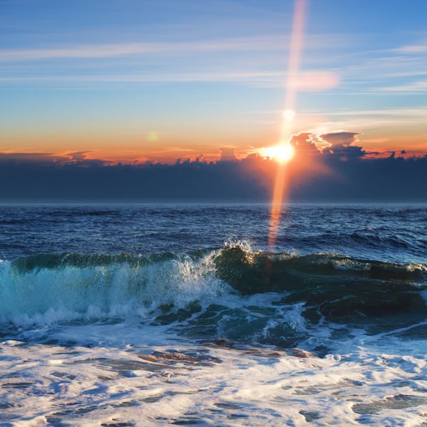 پس زمینه زیبای طلوع خورشید منظره دریا با امواج شکستن ابرهای صورتی