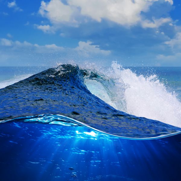 موج اقیانوس آبی سفید خشن در حال سقوط است