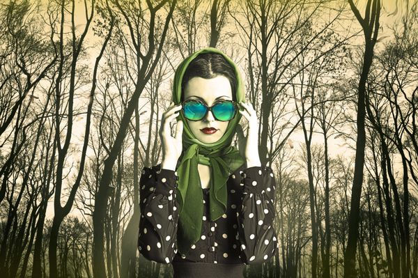 عکس هنری زیبا از یک زن زیبا با عینک آفتابی در جلوی درختان