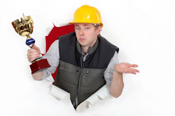 یک کارگر ساختمانی که یک جام جام در دست دارد