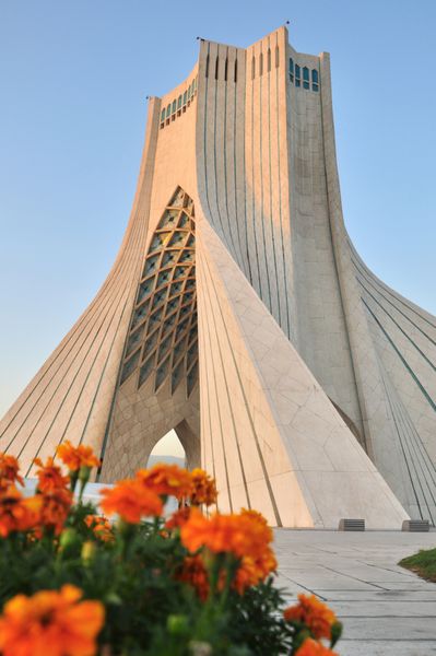 تهران ایران - حدود آگوست 2012 گلها در مقابل بنای یادبود برج آزادی در تهران در حدود اوت 2012 میدان آزادی و برج آزادی در سال 1971 ساخته شد