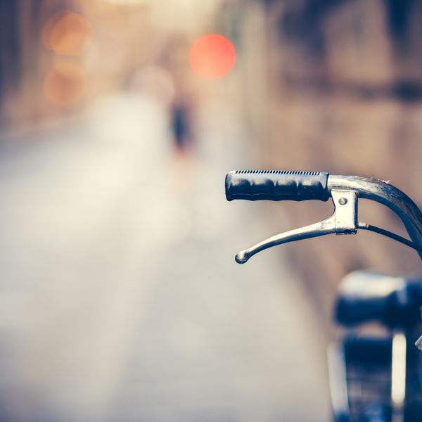 جزئیات یک دسته دوچرخه قدیمی که در خیابان باریک استراحت می کند تصویر رنگارنگ قدیمی
