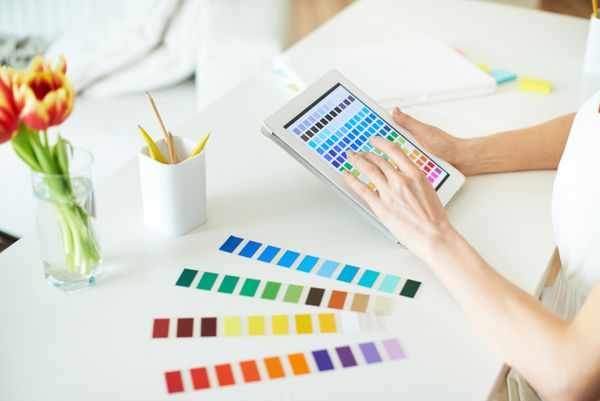 طراح زن که با رنگ ها در صفحه لمسی کار می کند