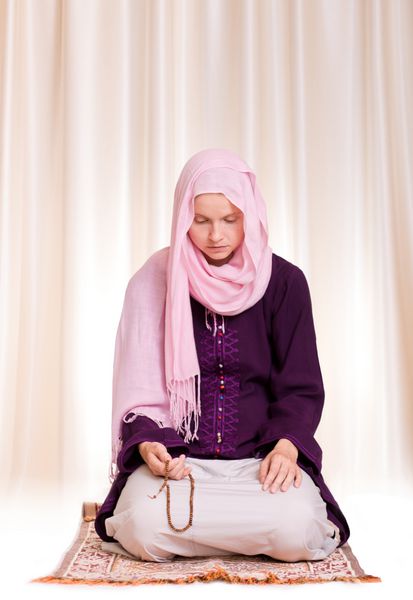 زن جوان مسلمان در حال دعا با تسبیح