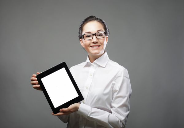 زن تجاری که یک رایانه لوحی در دست دارد - جدا شده روی پس زمینه خاکستری