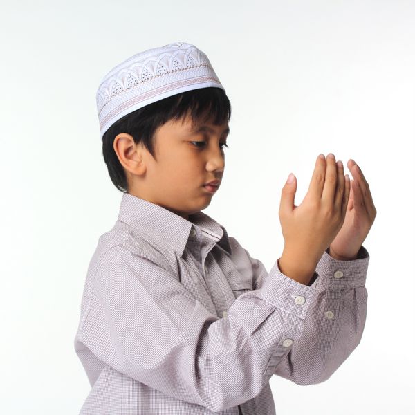 توضیح دعای اسلامی کودک آسیایی که در حین نماز حرکات مسلمان را کامل نشان می دهد
