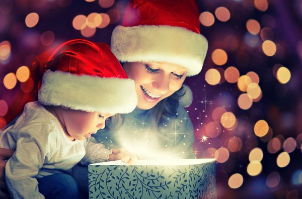 جعبه هدیه جادویی کریسمس و یک زن خانواده شاد مادر و کودک کودک