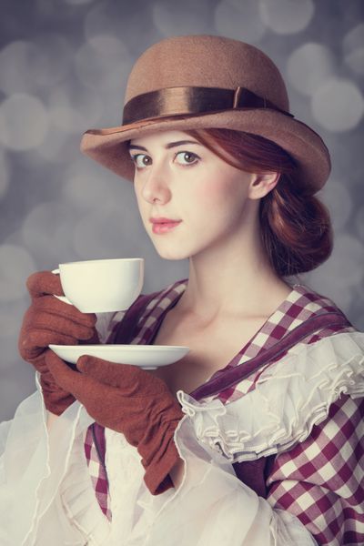 زنان مو قرمز زیبا با فنجان چای عکس به سبک رترو با بوکه در پس زمینه