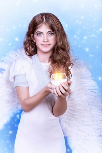 أƒأ‚آگأƒأ‚آ فرشته ute پرتره دختر نوجوان زیبا که بالهای کرکی پوشیده و شمعی را در دستانش در پس زمینه برفی پاکی و مفهوم معصومیت دارد