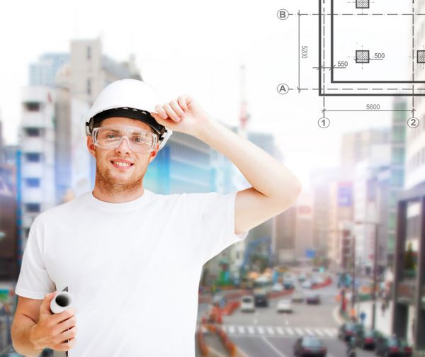 مفهوم ساختمان توسعه ساخت و ساز و معماری - معمار مرد در کلاه ایمنی با طرح و عینک ایمنی