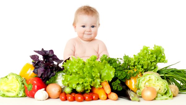 نوزاد در محیطی از سبزیجات تازه جدا شده روی سفید