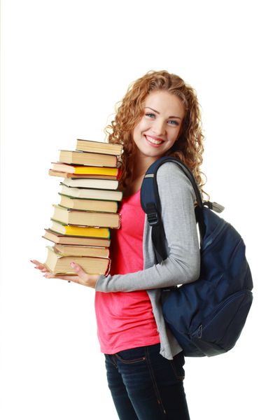 دختر دانشجوی خندان زیبا که انبوهی از کتاب ها را در دست دارد