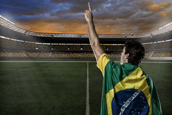 فوتبالیست برزیلی با پرچم برزیل بر پشتش و با هواداران جشن می گیرد