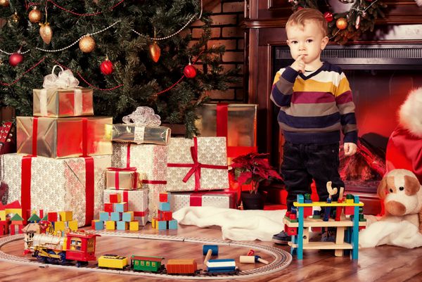 اتاقی که به زیبایی برای کریسمس با هدایا و اسباب بازی های فراوان تزئین شده است
