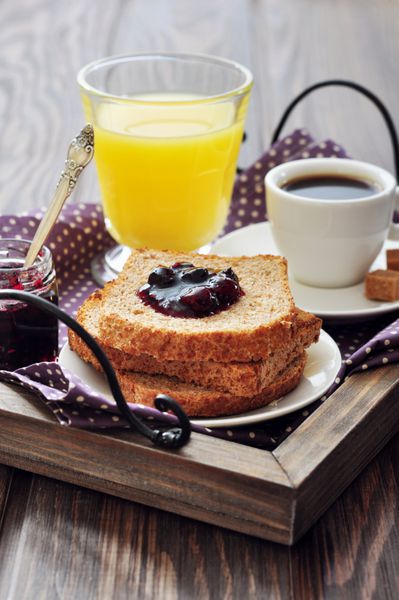 صبحانه با نان تست مربای میوه آب پرتقال و قهوه در سینی