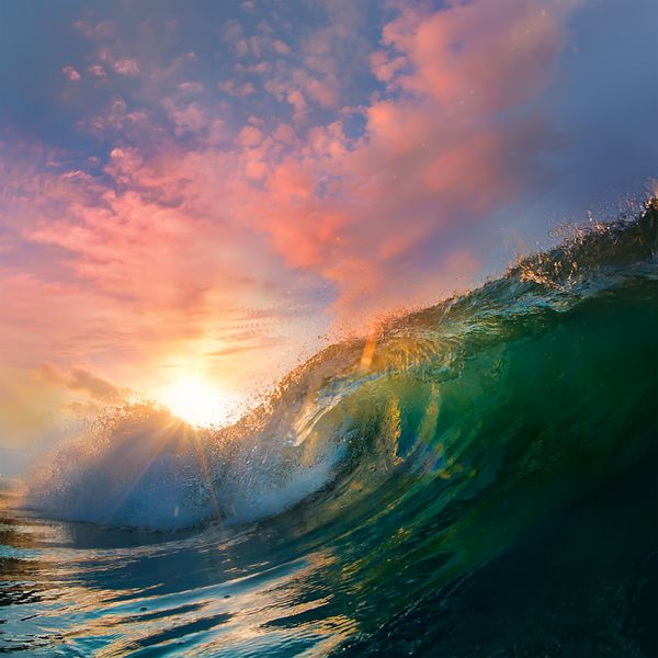 موج زیبای موج‌سواری اقیانوس در زمان غروب آفتاب