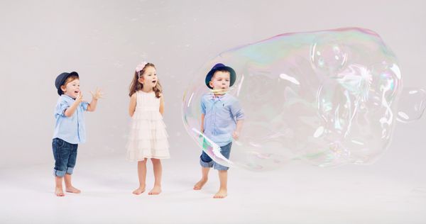 بچه های دوست داشتنی که با حباب های صابون بازی می کنند