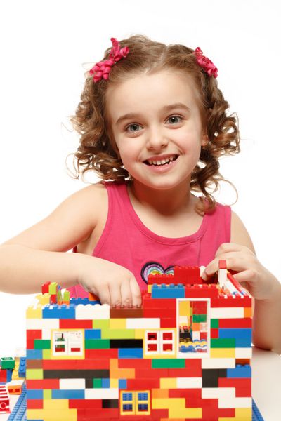 دختر کوچکی از بلوک های پلاستیکی خانه می سازد