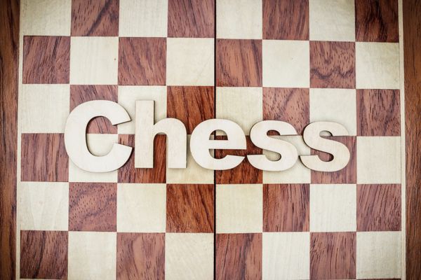 کلمه شطرنج در زمینه چوبی قهوه ای