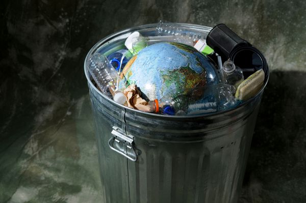 زمین در سطل زباله با پلاستیک و زباله