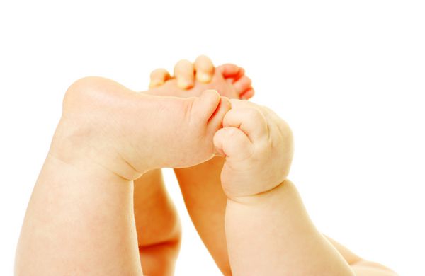 پاها و دست های نوزاد تازه متولد شده روی سفید جدا شده اند