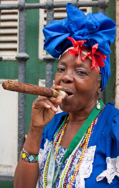 هاوانا - 19 مه بانویی در حال کشیدن سیگار بزرگ 19 مه 2011 در هاوانا شخصیت های نمادین مانند این جاذبه برای بیش از 2 میلیون گردشگر است که هر سال به کوبا می روند تا از فرهنگ متمایز آن لذت ببرند