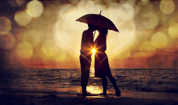 زن و شوهر در حال بوسیدن زیر چتر در ساحل در غروب آفتاب عکسی به روش تصاویر قدیمی