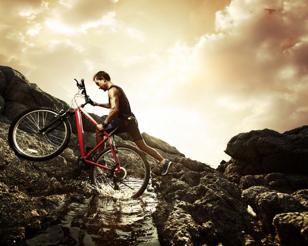 عبور ورزشکار جوان از سد آبی با دوچرخه