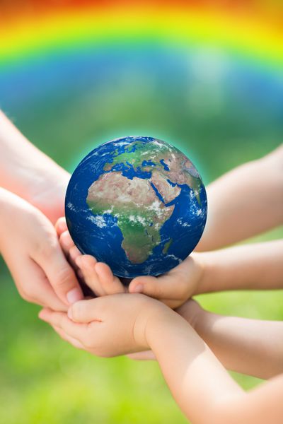 کودکانی که زمین را در دستان خود در پس زمینه سبز بهار نگه می دارند عناصر این تصویر توسط ناسا ارائه شده است