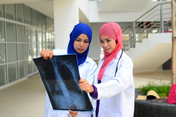 دانشجوی مسلمان پزشکی با اعتماد به نفس مشغول گفتگو با هم در بیمارستان