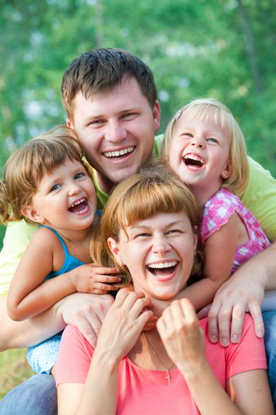 پرتره سبک زندگی خانوادگی از یک مادر و پدر به همراه فرزندانشان در حال داشتن اوقات خوشی در پارک سبز