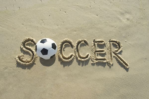 پیام فوتبال دست‌نویس فوتبال با حروف بزرگ در ساحل شنی و آفتابی برزیل