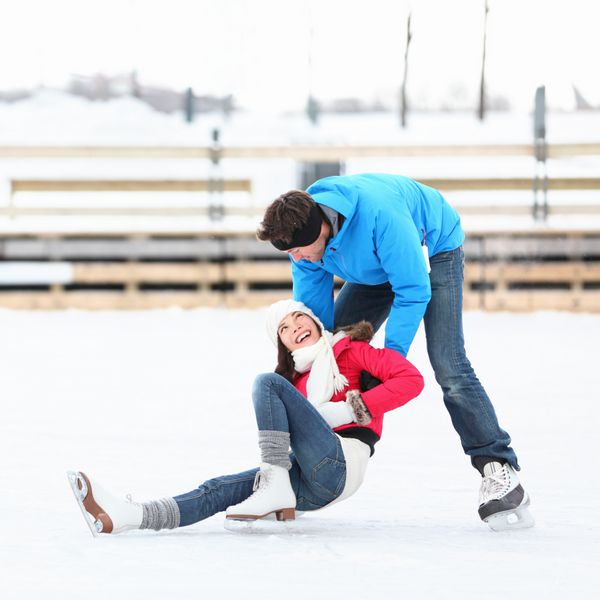 زوج اسکیت روی یخ در حال تفریح زمستانی روی اسکیت های یخ در بندر اولد مونترال کبک کانادا