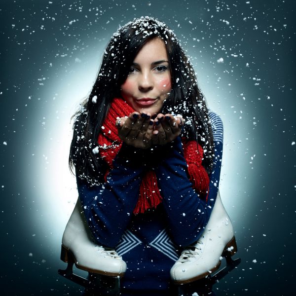 دختر جوان خندان با اسکیت پرتره زمستانی بارش برف