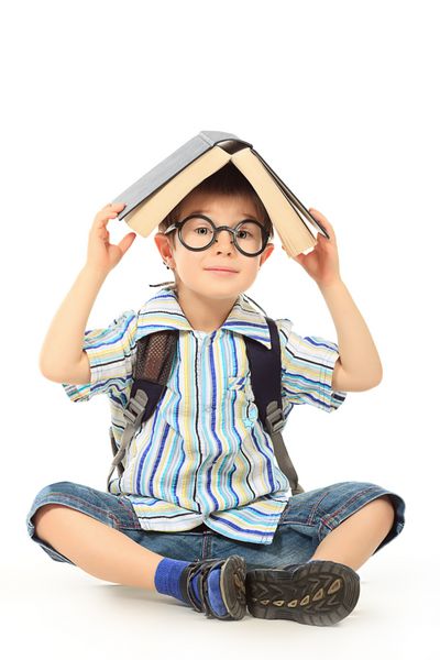 پرتره پسر بچه ای در عینک در حال خواندن کتاب با زمینه سفید مجزا شده است