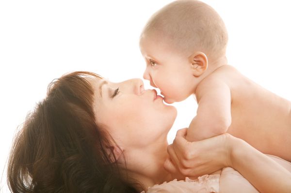 پرتره مادر زیبا که نوزاد را روی سفید می بوسد