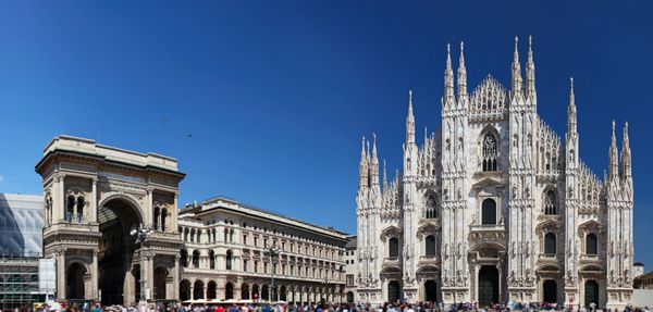 Piazza del Duomo در میلان ایتالیا با Duomo در سمت راست و طاق ورودی به Galleria Vittorio Emanuele II در سمت چپ