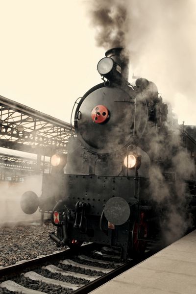 لوکوموتیو بخار در ایستگاه راه‌آهن در ابر پیچیده شده است - رنگ‌بندی قدیمی قدیمی