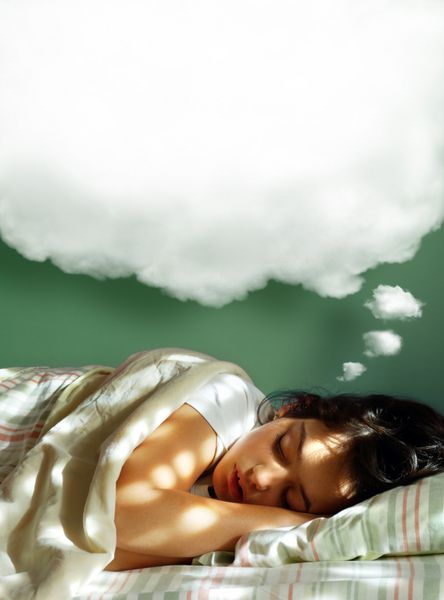 دختر جوانی که روی تختش خوابیده است با یک بادکنک کرکی رویایی بالای سرش