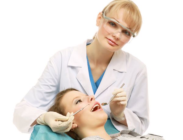 دندانپزشکی که در کلینیک دندانپزشکی روی دندان کار می کند