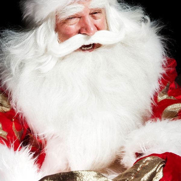 بابا نوئل در اتاق کریسمس نشسته و به گونی نگاه می کند