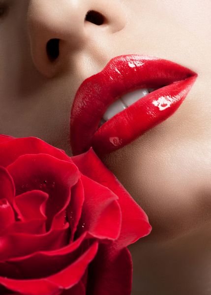 عکس نزدیک از لب های زن با رژ لب قرمز و گل رز
