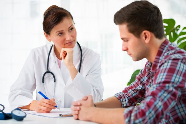 دکتر در حال صحبت با بیمار مرد خود در مطب