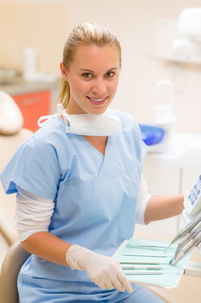 کارکنان حرفه ای دندانپزشکی با ابزارهای پزشکی در مطب جراحی نشسته اند