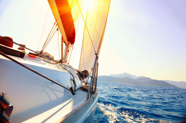 قایق بادبانی در برابر غروب آفتاب قایق بادبانی قایقرانی کشتیرانی مفهوم سفر تعطیلات