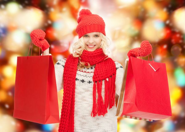 تعطیلات فروش خرید مفهوم کریسمس - دختر نوجوان زیبا در لباس های زمستانی با کیسه های خرید