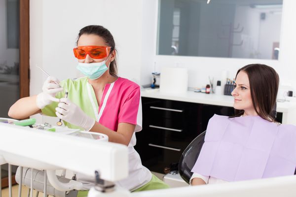 پرتره زن دندانپزشک و بیمار در کلینیک دندانپزشکی