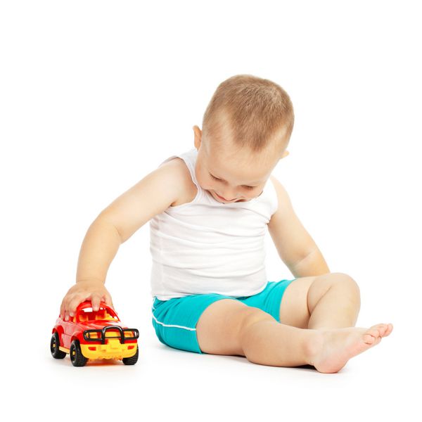 پسر بچه با ماشین اسباب بازی بازی می کند